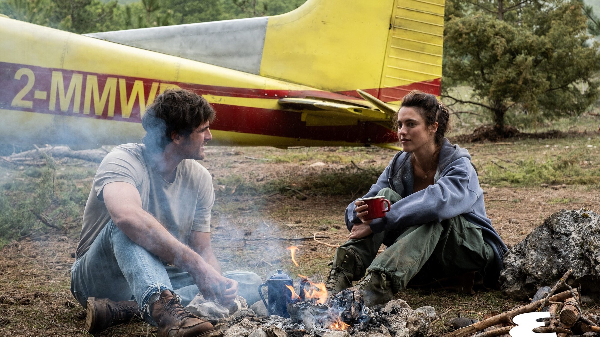 Official still from 20th Century Studios' The Dog Stars. Jacob Elordi and Margaret Qualley by the Cessna campfire. Photo via Esquire first look.