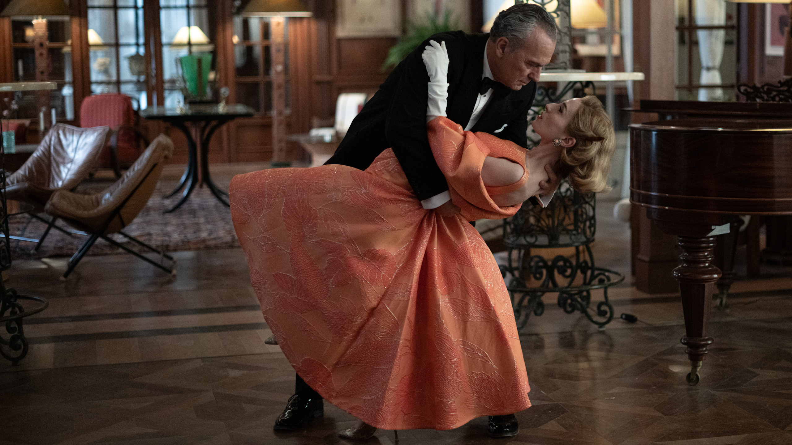 Official Netflix still from The Final Problem: period formalwear and a dance dip inside the sealed-hotel world. Netflix.