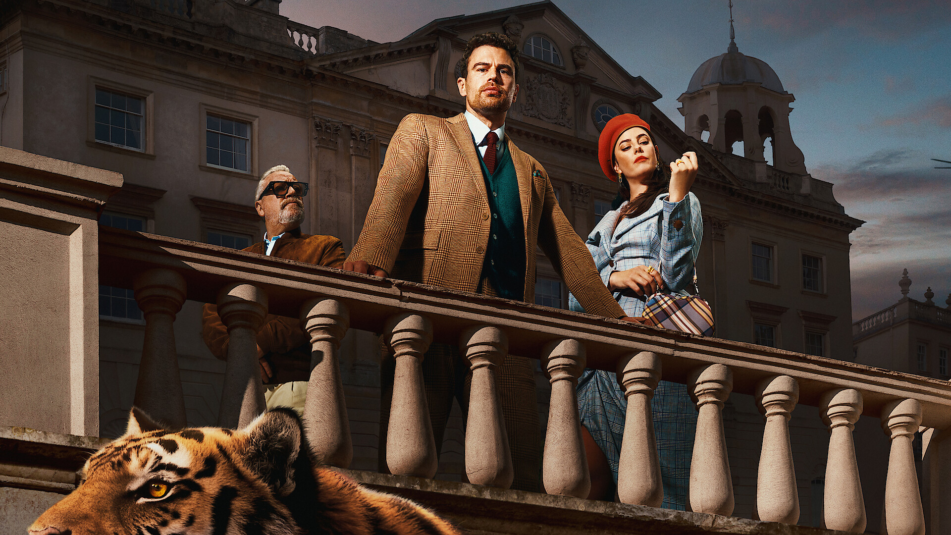 Official Netflix still from The Gentlemen: Theo James, Kaya Scodelario, and Ray Winstone on the manor balcony. Courtesy Netflix Tudum.
