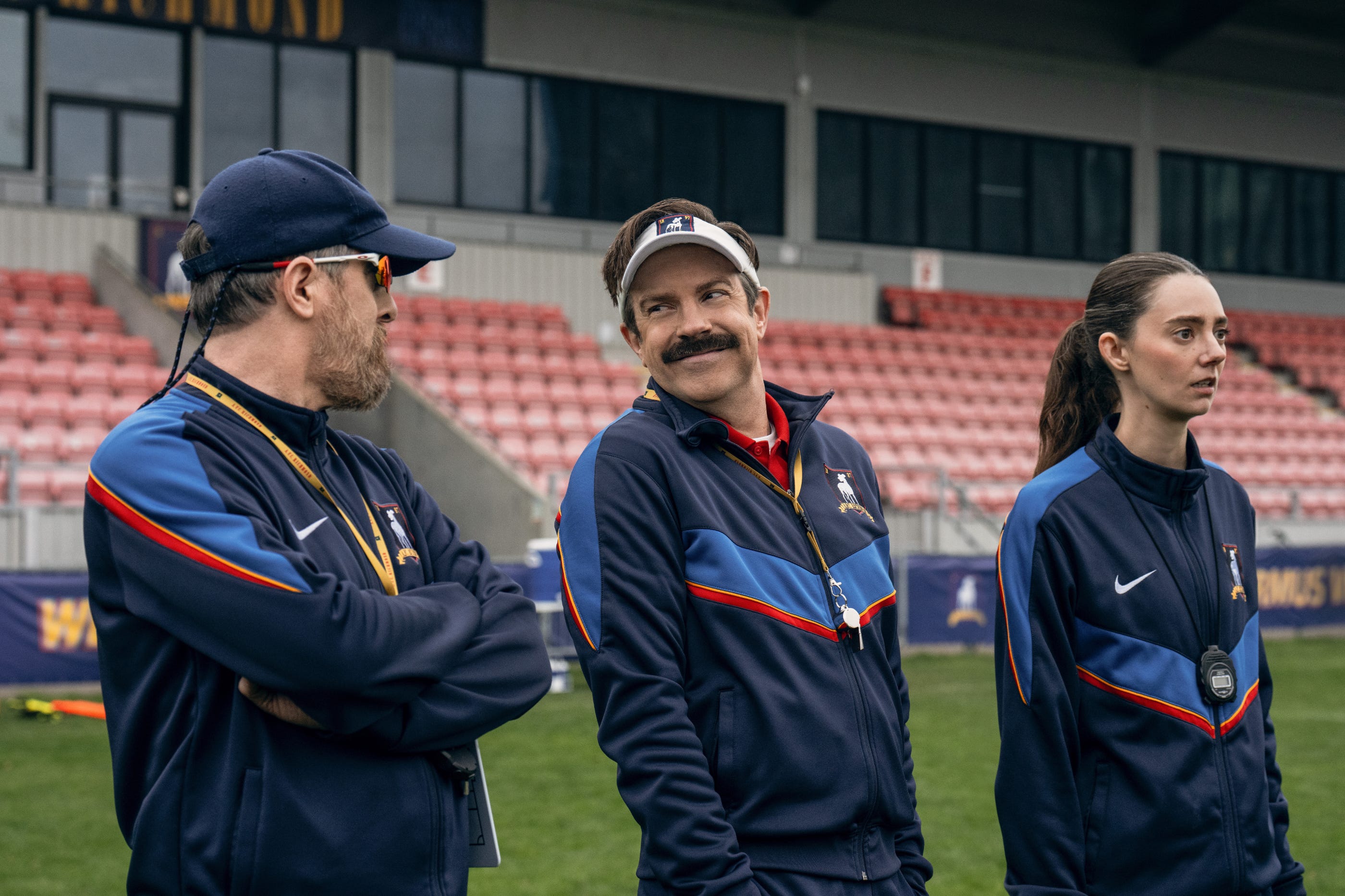 Official Apple TV still from Ted Lasso Season 4: Jason Sudeikis as Ted with Brendan Hunt as Coach Beard on the Richmond sideline. Colin Hutton / Apple TV.