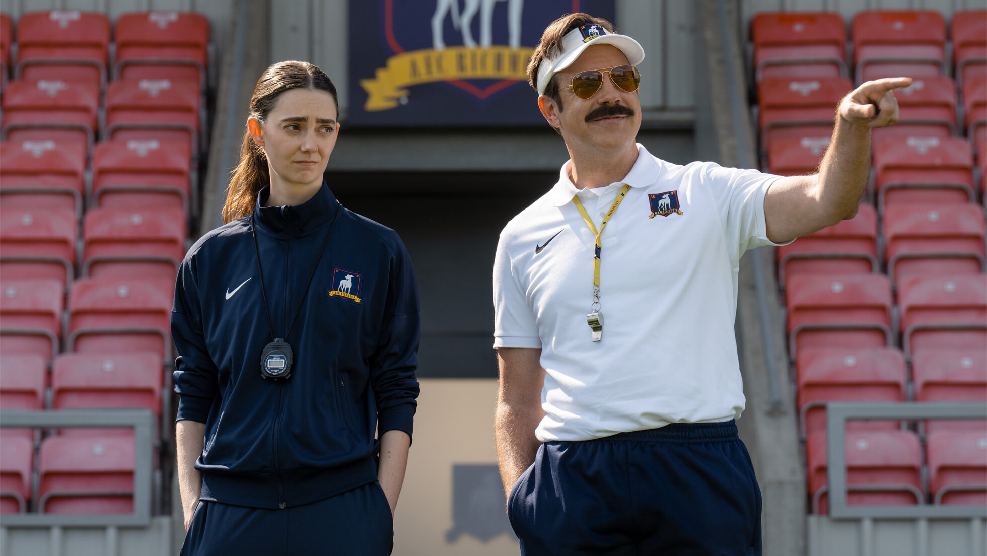 Official Apple TV still of Jason Sudeikis as Ted Lasso and Tanya Reynolds as Alice Chilton on the Richmond pitch in season four. Apple TV Press, January 28, 2026.