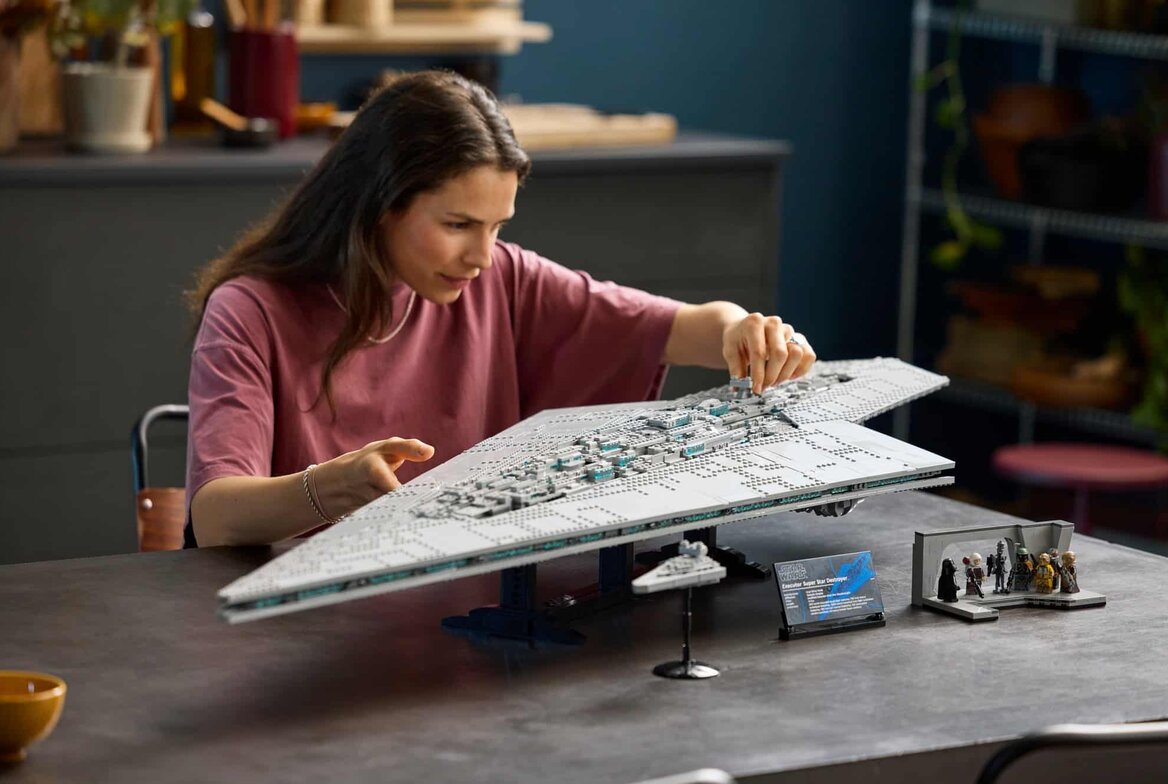 Official LEGO lifestyle shot of UCS Executor Super Star Destroyer (75457) on its built-in stand with the to-scale Star Destroyer, display plaque, and bridge minifigure scene. The LEGO Group.
